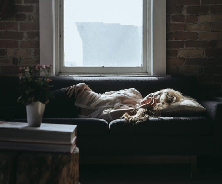 A cat lying on top of a fire place sitting in a living room