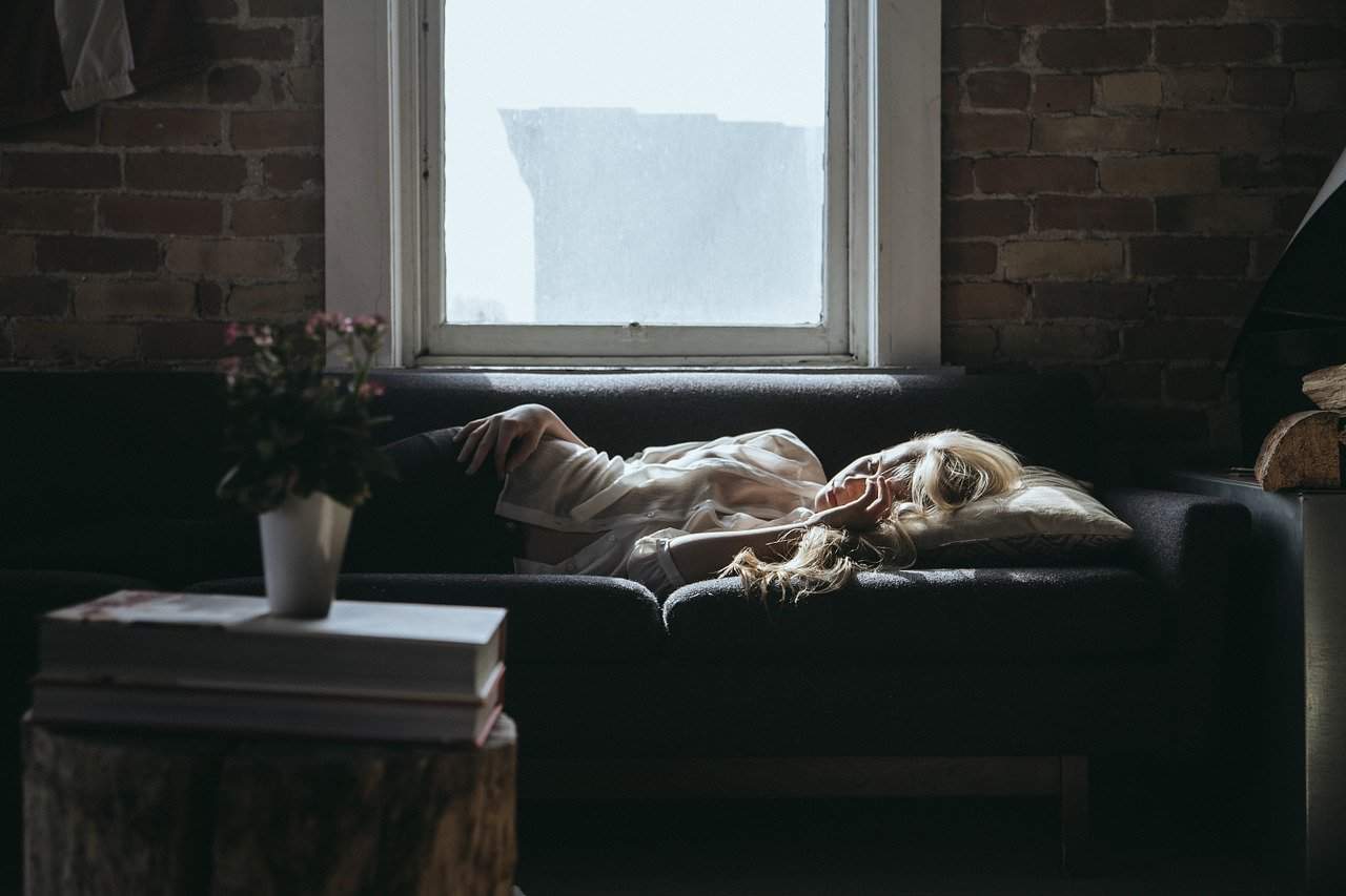 A cat lying on top of a fire place sitting in a living room