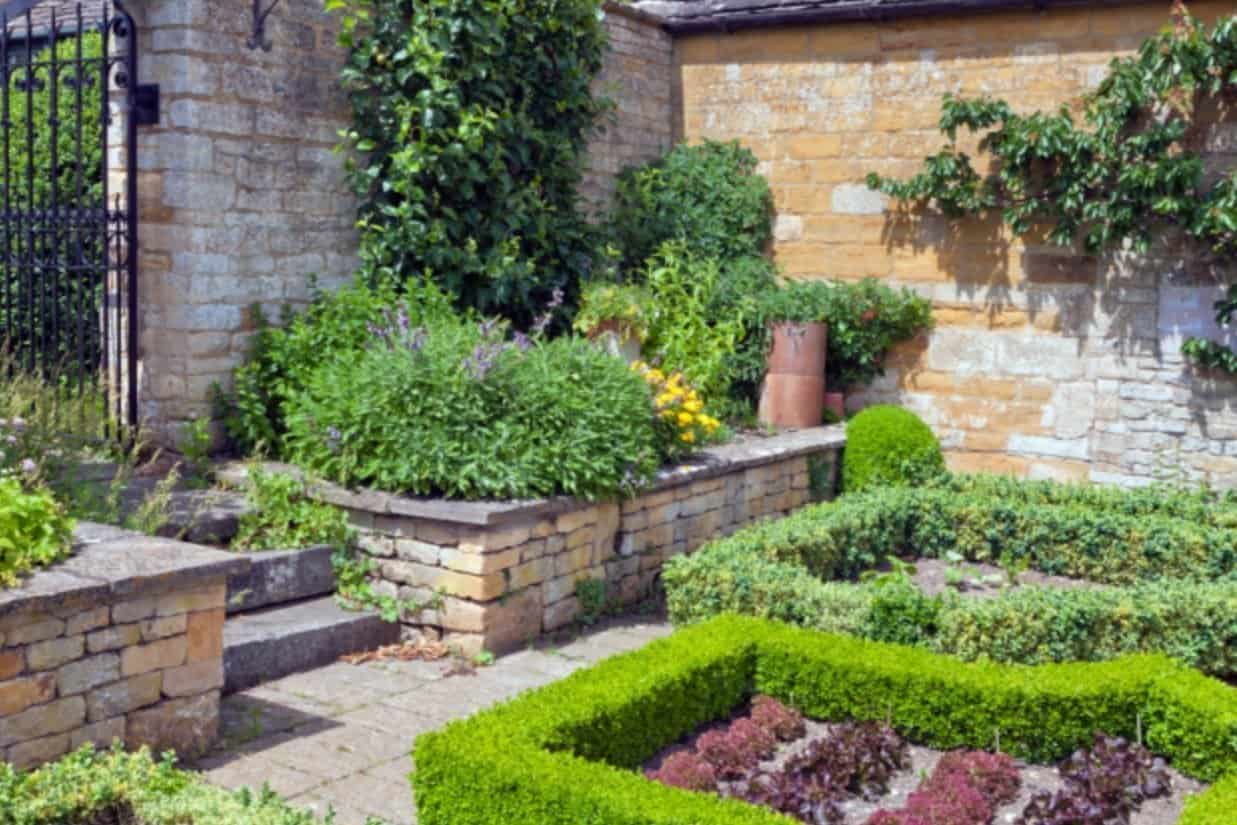 A close up of a flower garden in front of a brick building