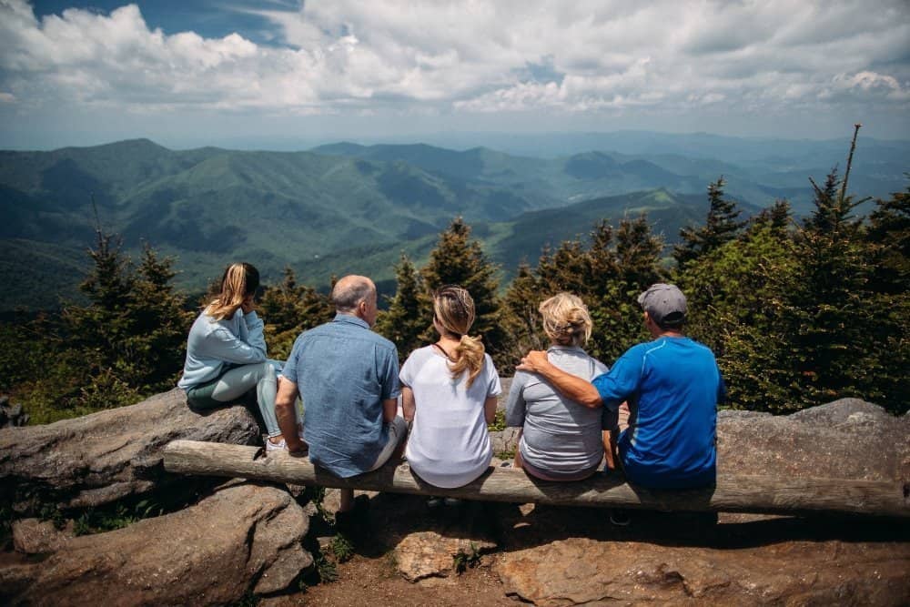 A group of people sitting on the side of a mountain