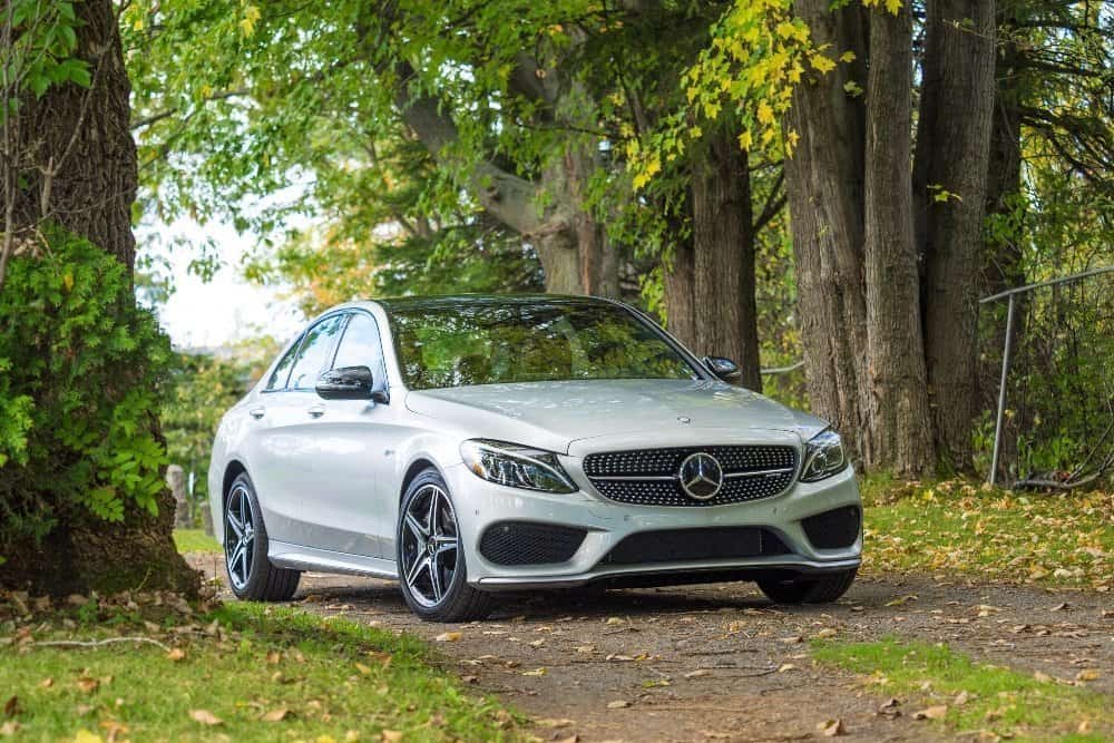 A car parked on pavement near a forest