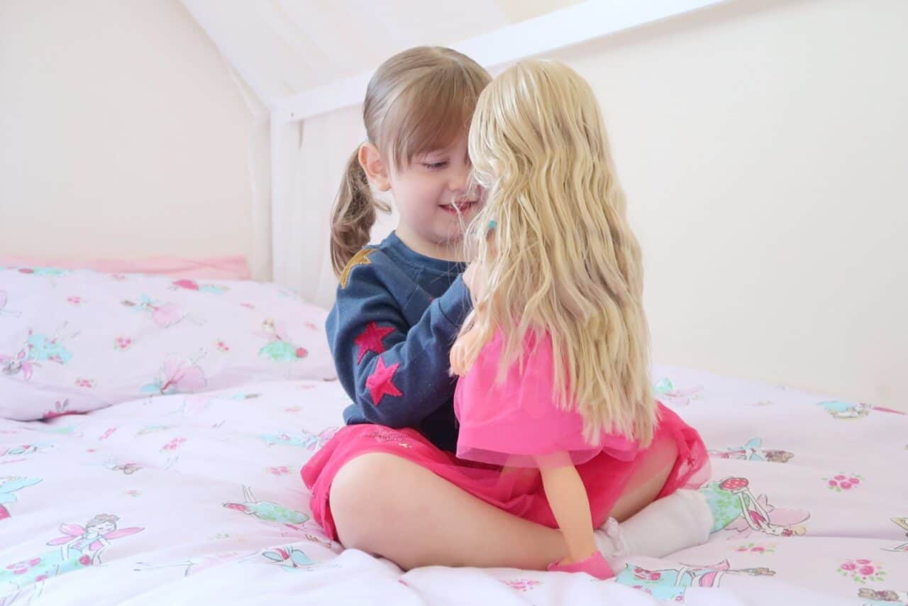 A little girl sitting on a bed