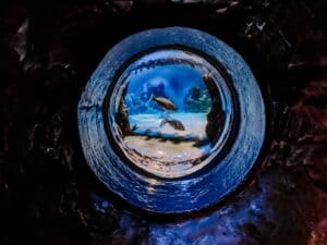 A blue fire hydrant sitting in the dark