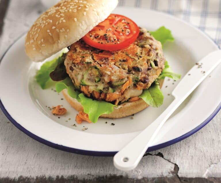 A sandwich sitting on top of a plate of food, with Salmon