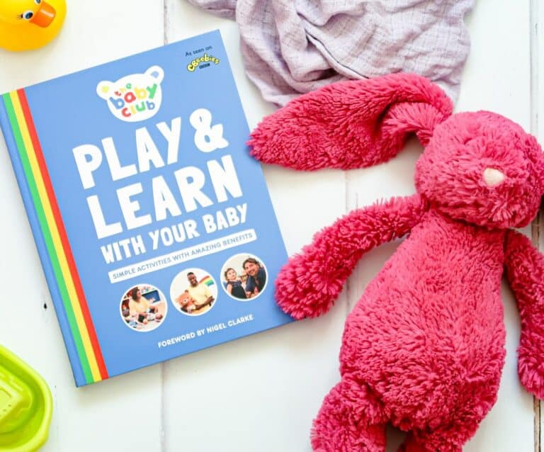 A group of stuffed animals sitting next to a teddy bear