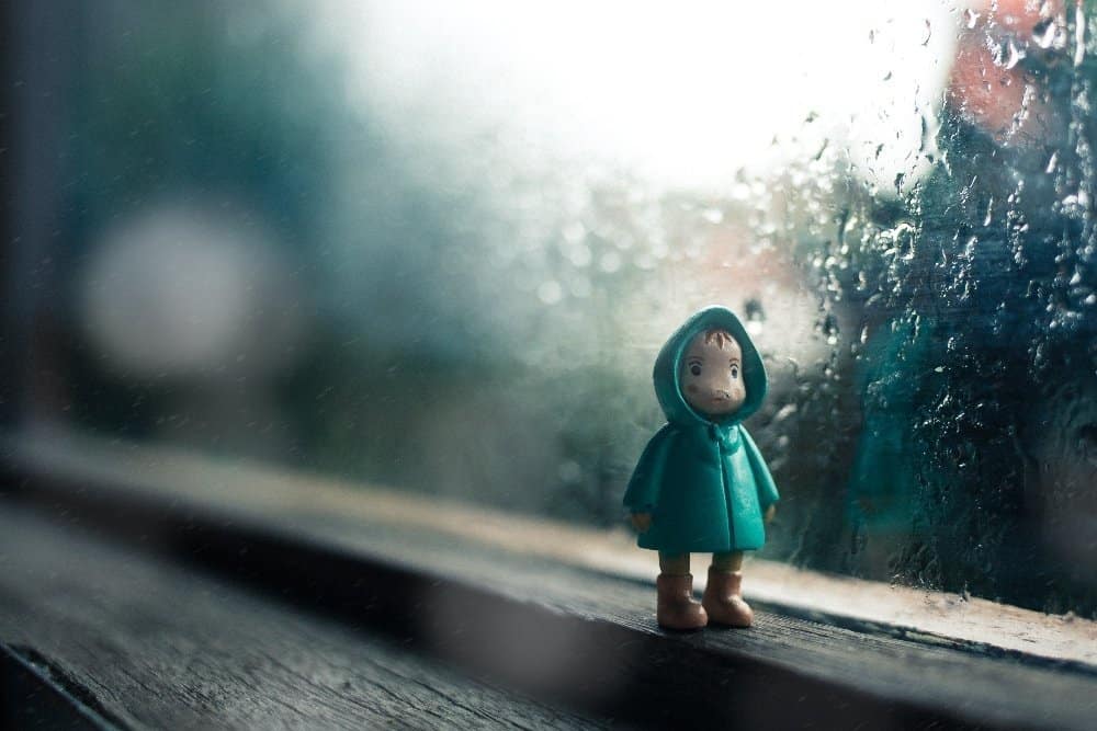 A young girl riding a wave on a surfboard in the rain