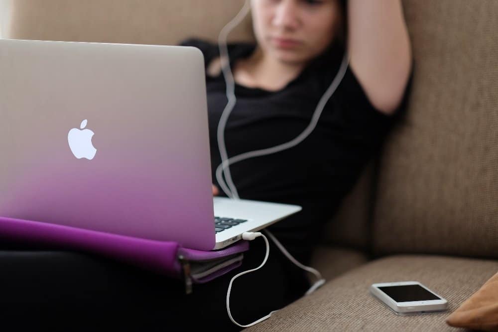 A person sitting at a table using a laptop computer