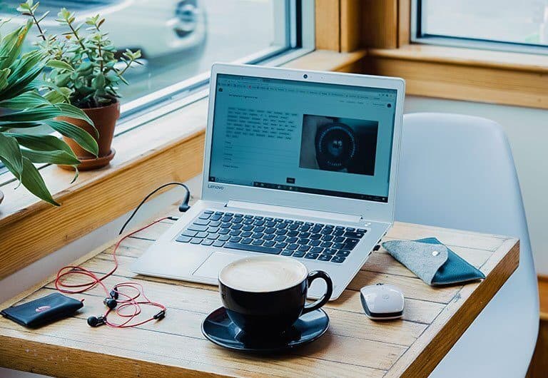 A laptop computer sitting on top of a wooden table