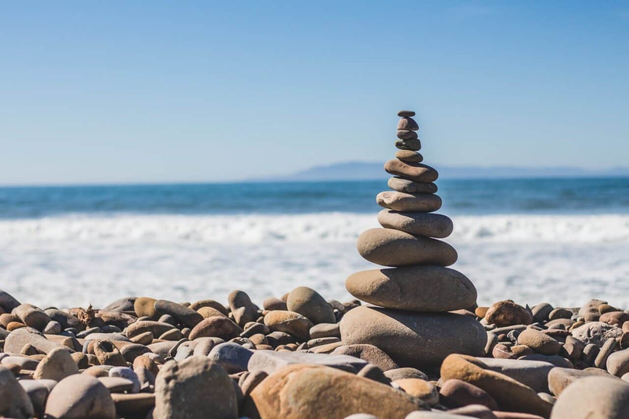 A herd of sheep standing on a rocky beach