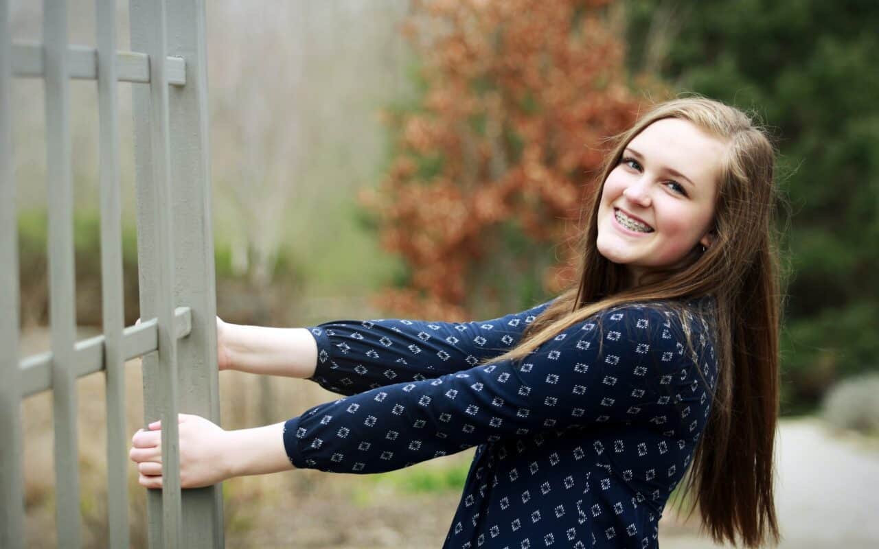 A woman standing in front of a fence