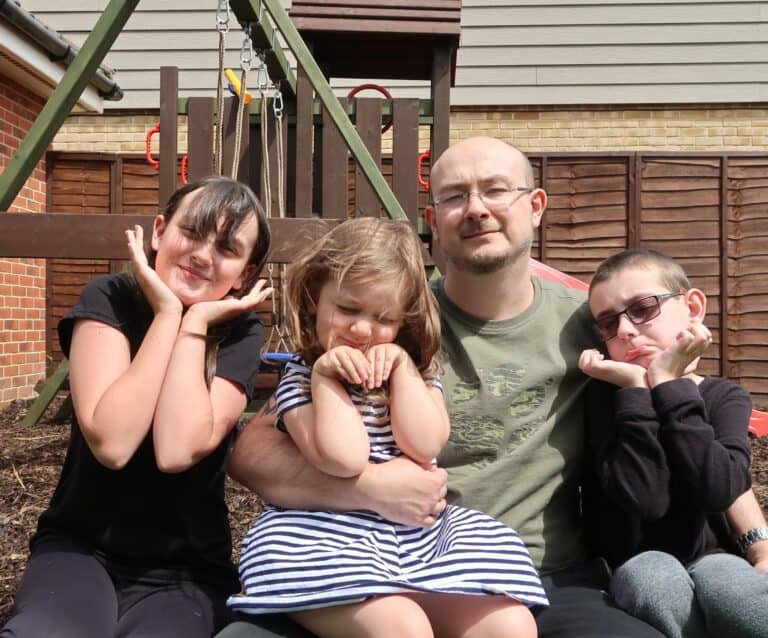 A group of people sitting on a bench posing for the camera