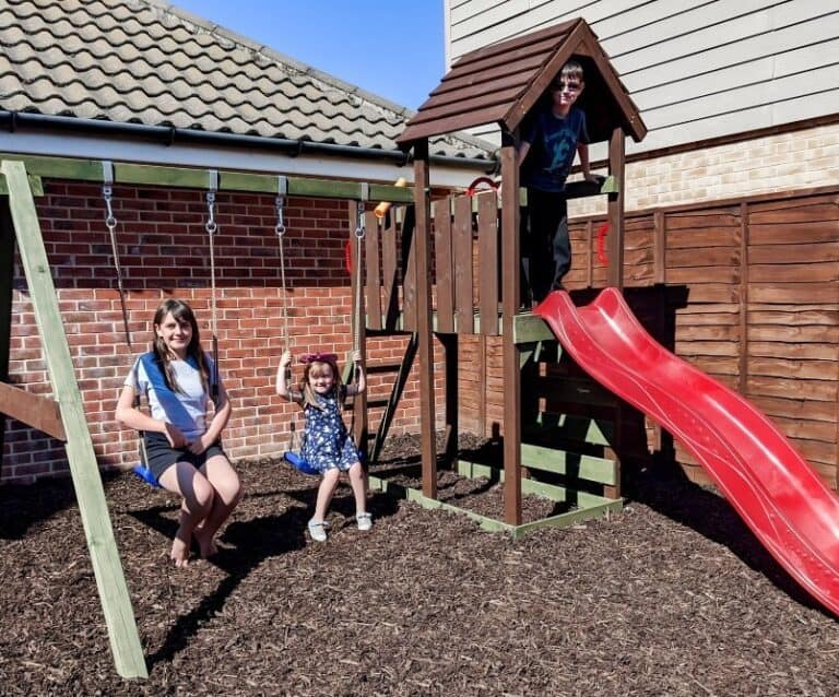 Children playing on a wooden climbing frame