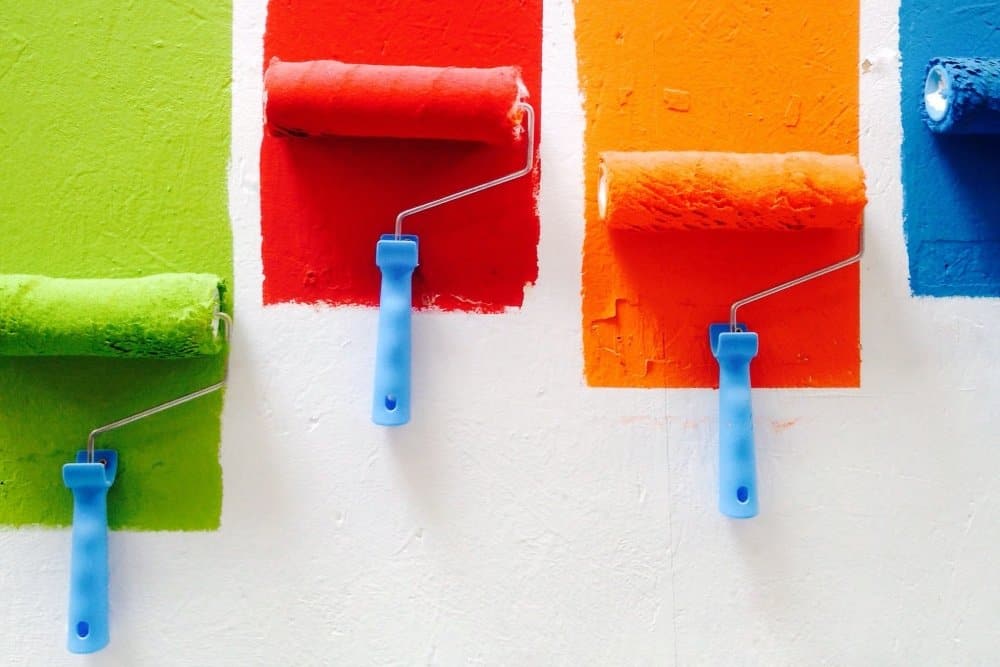 colourful paint rollers on a white background