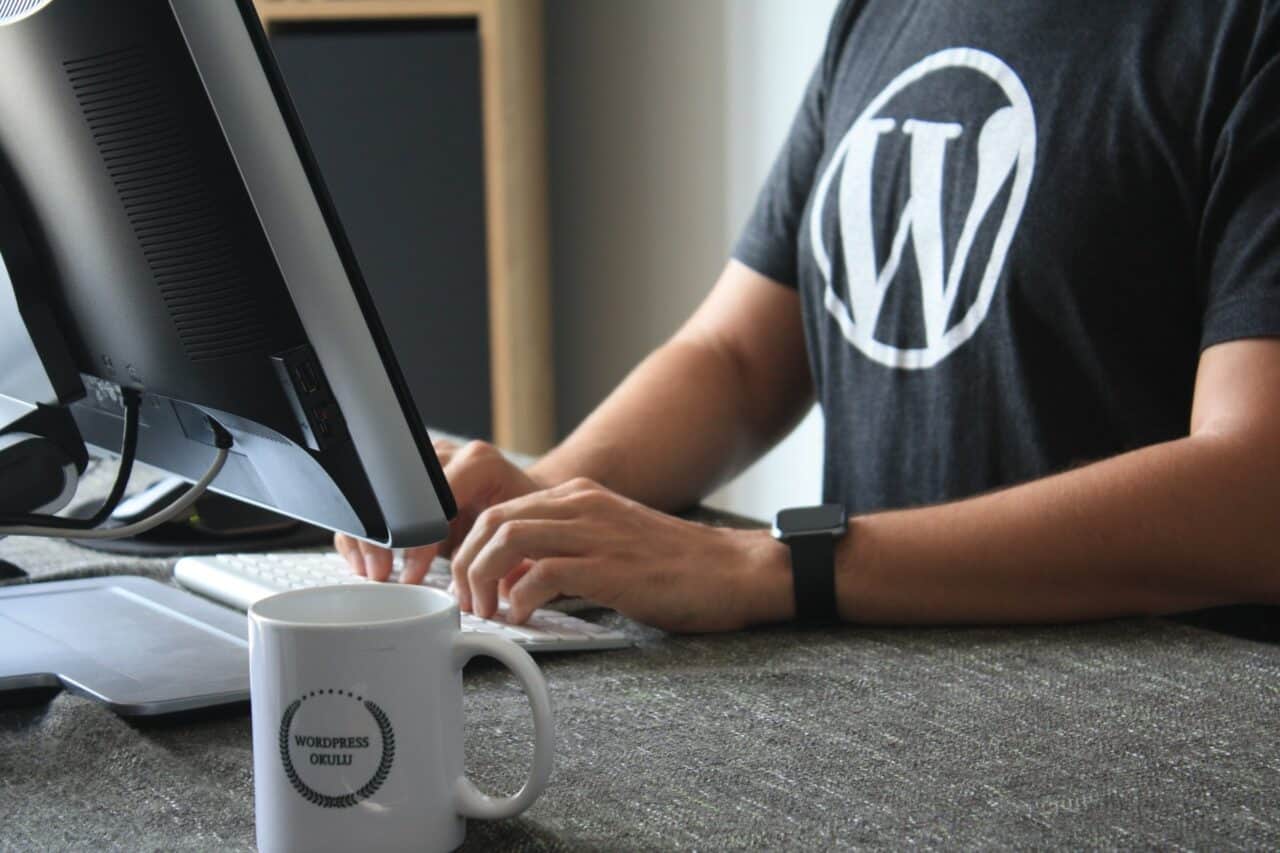 A man sitting at a table using a laptop computer