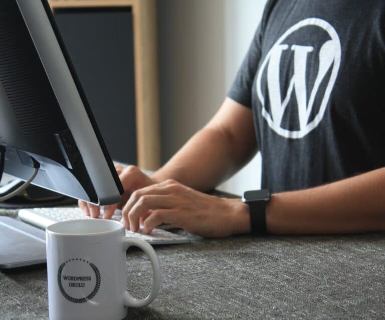 A man sitting at a table using a laptop computer