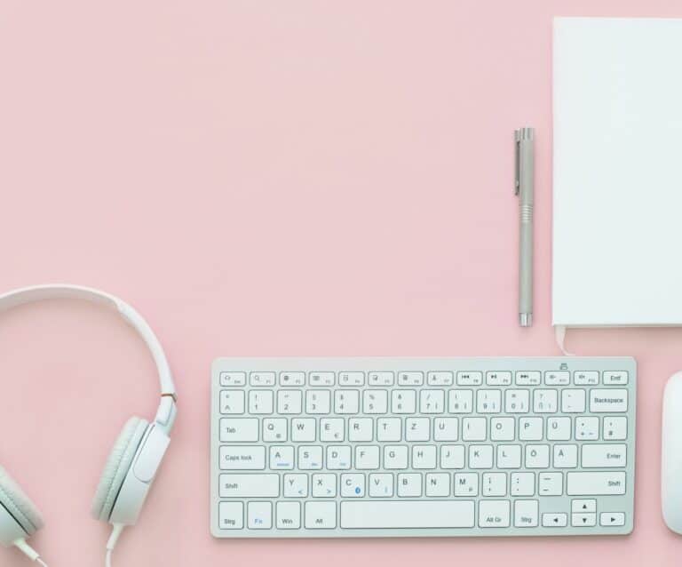 A close up of a computer keyboard on a pink background