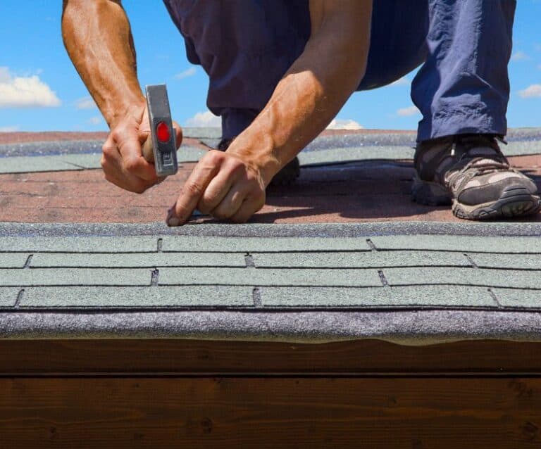 gardener renew roof of summer garden house with tar paper shingles