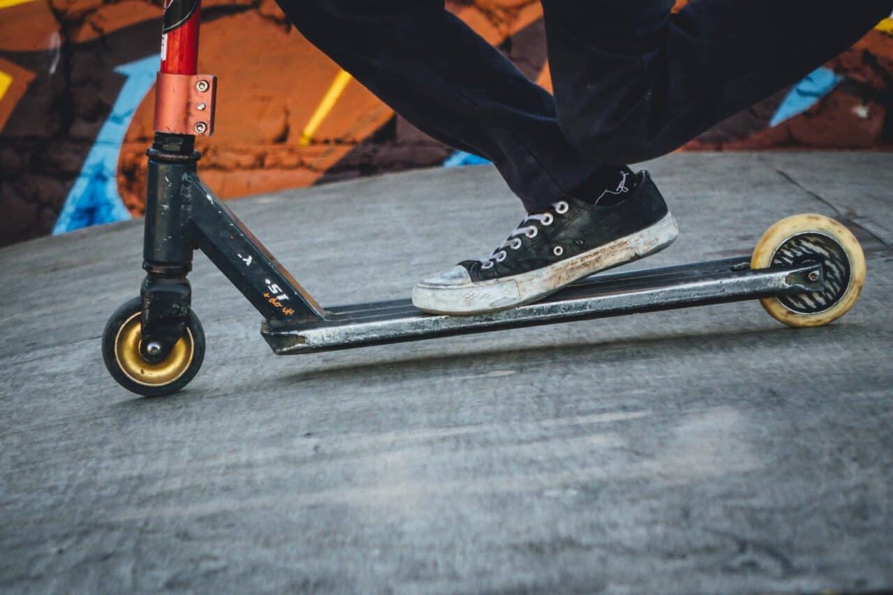 person riding black and grey scooter kickboard