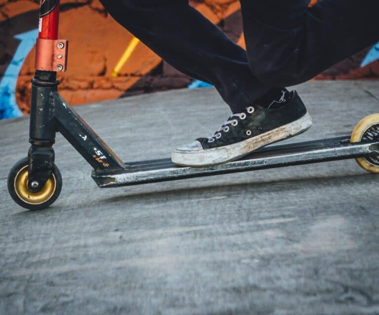 person riding black and grey scooter kickboard