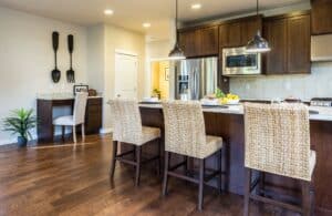 three brown wooden chairs in front of a breakfast bar