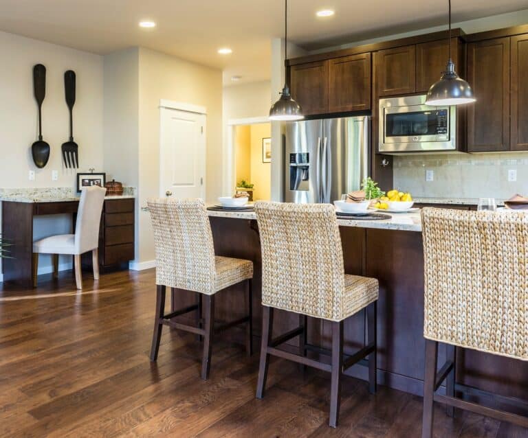 three brown wooden chairs in front of a breakfast bar