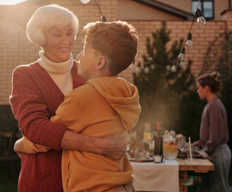 elderly woman hugging her grandson