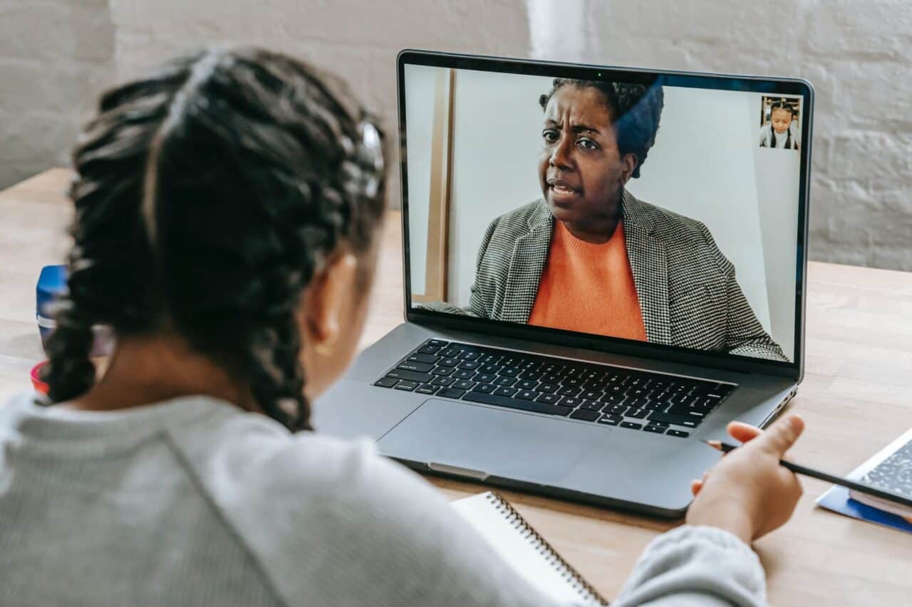 clever ethnic girl having conversation with teacher online