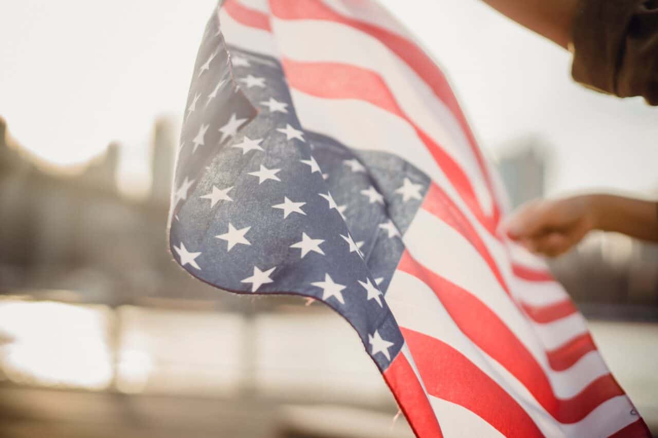 crop person holding american flag in wind