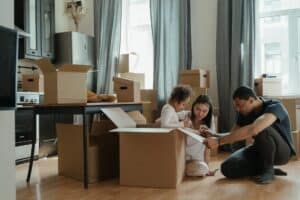 Ways To Make Moving With Kids Fun and Stress-Free - family unpacking after moving