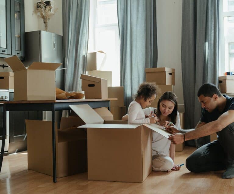 Ways To Make Moving With Kids Fun and Stress-Free - family unpacking after moving