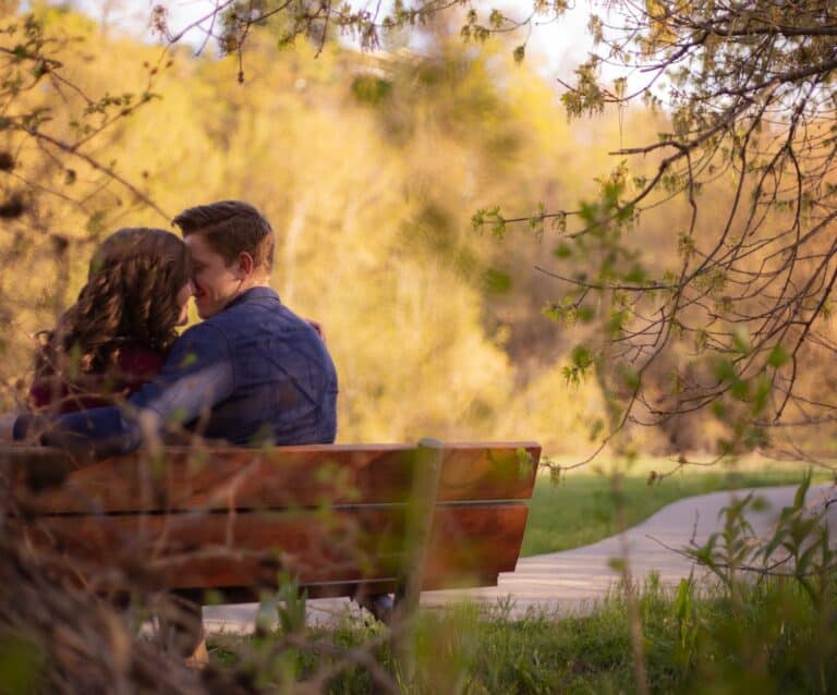 photography of couple sitting on bench