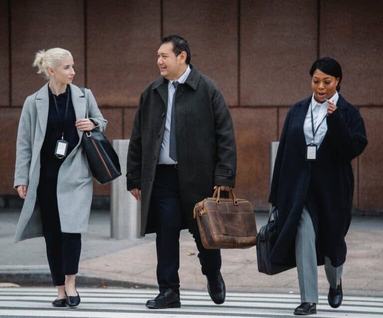 Why Dressing Well For Work Is Important - stylish multiethnic colleagues talking while walking on urban roadway