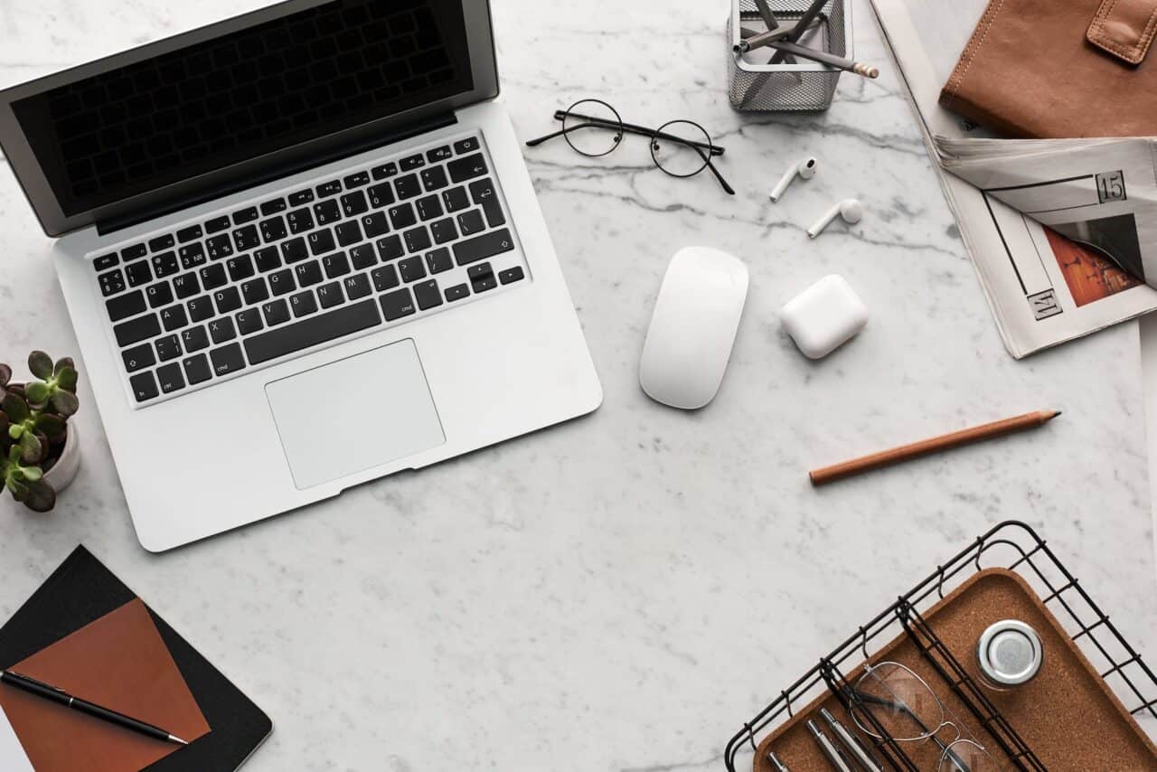 flatlay display of electronics next to eyeglases