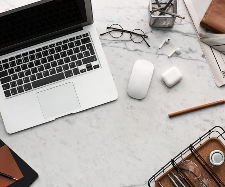 flatlay display of electronics next to eyeglases