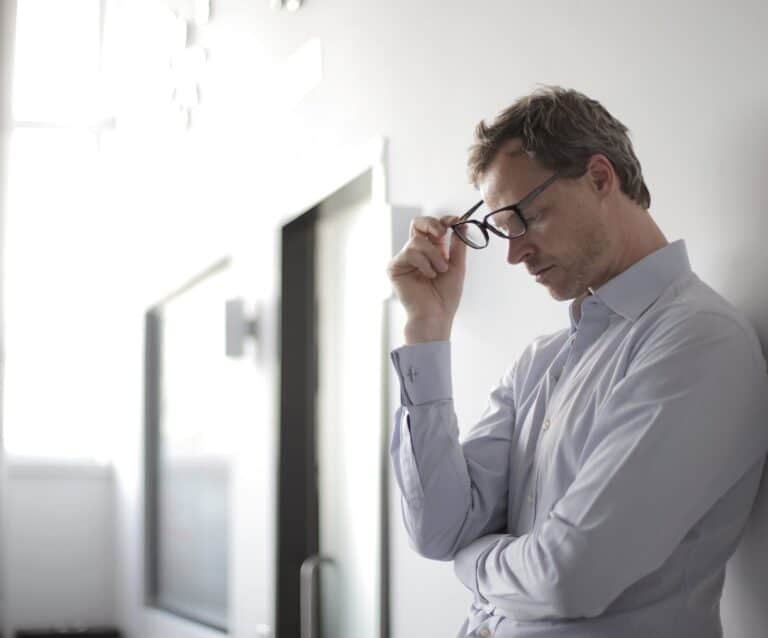 photo of man holding black eyeglasses