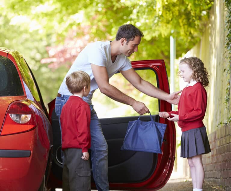 Father Driving To School With Children