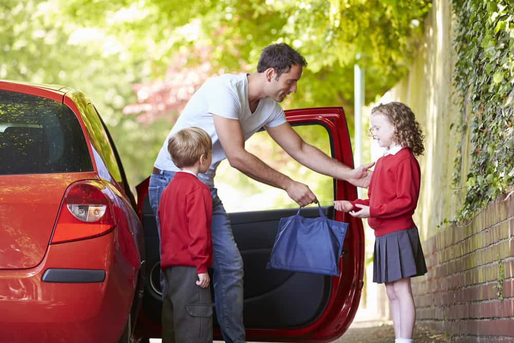 Father Driving To School With Children