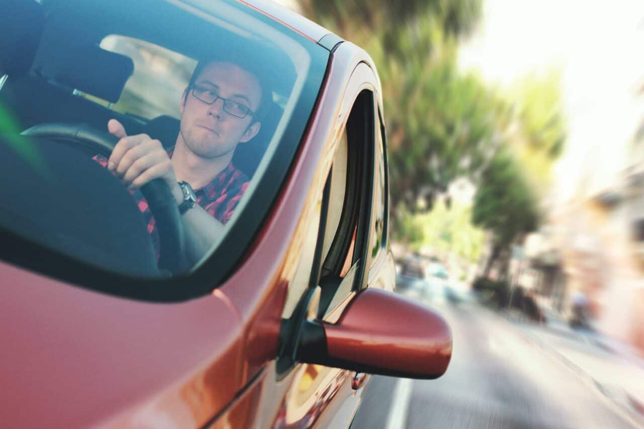 man driving the red vehicle