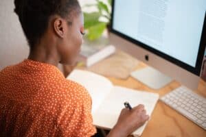 woman writing on her notebook