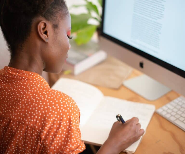 woman writing on her notebook