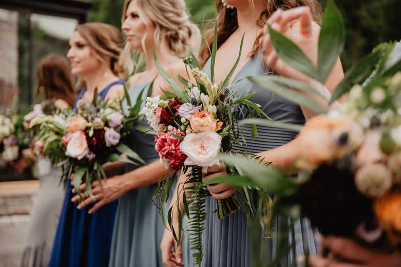 selective focus photography of women holding wedding flowers