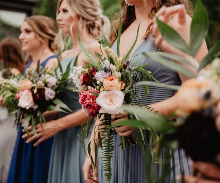 selective focus photography of women holding wedding flowers