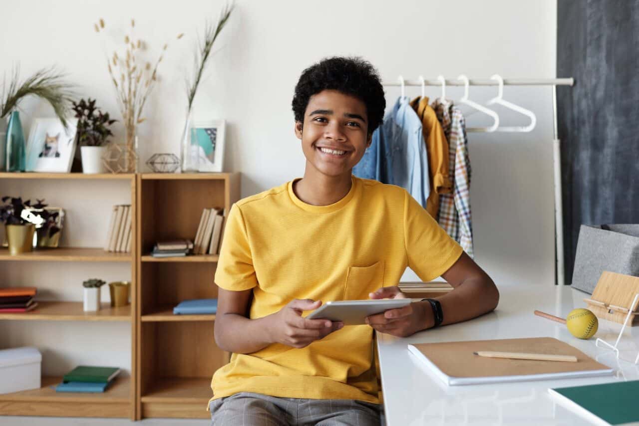 boy in yellow crew neck t shirt sitting on chair