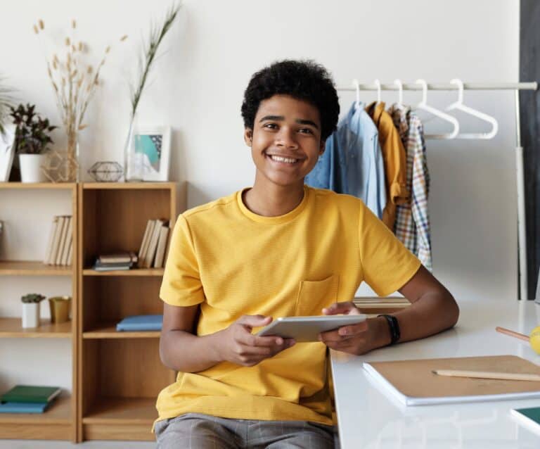 boy in yellow crew neck t shirt sitting on chair