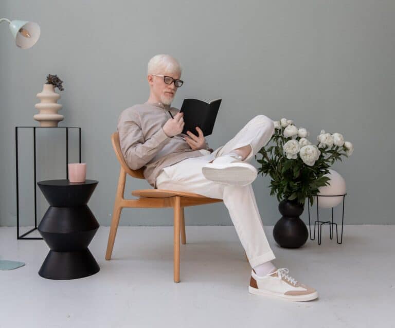 businessman reading diary on chair in room with decor