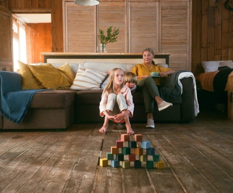 woman sitting on a couch looking after two children