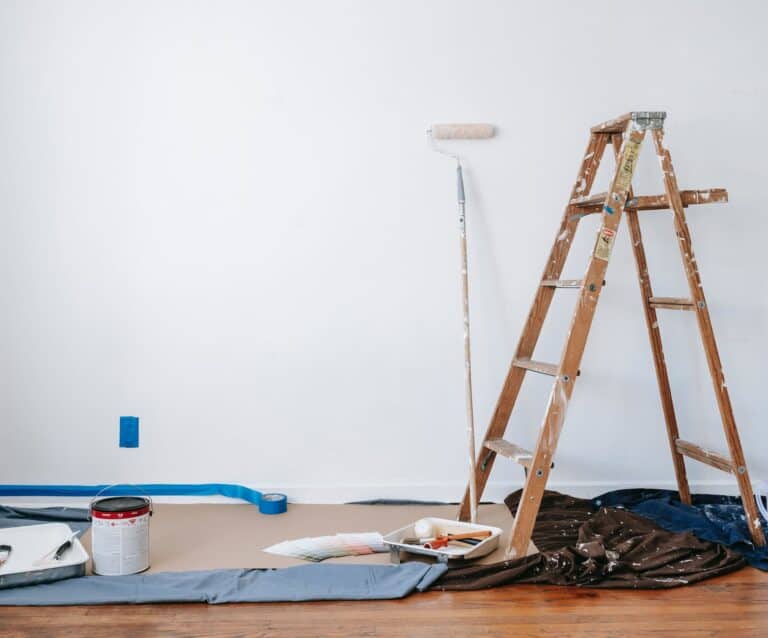 brown wooden ladder beside painting materials