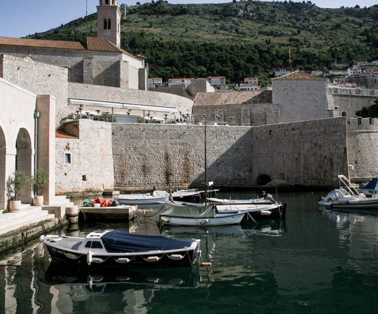 boats on calm sea water and stone fort