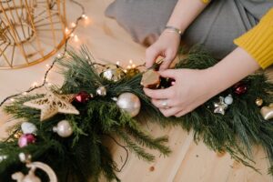 close up shot of a person holding a christmas wreath