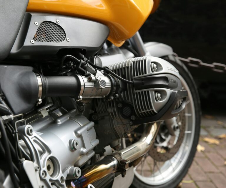 yellow and gray motorcycle parks near chain rail